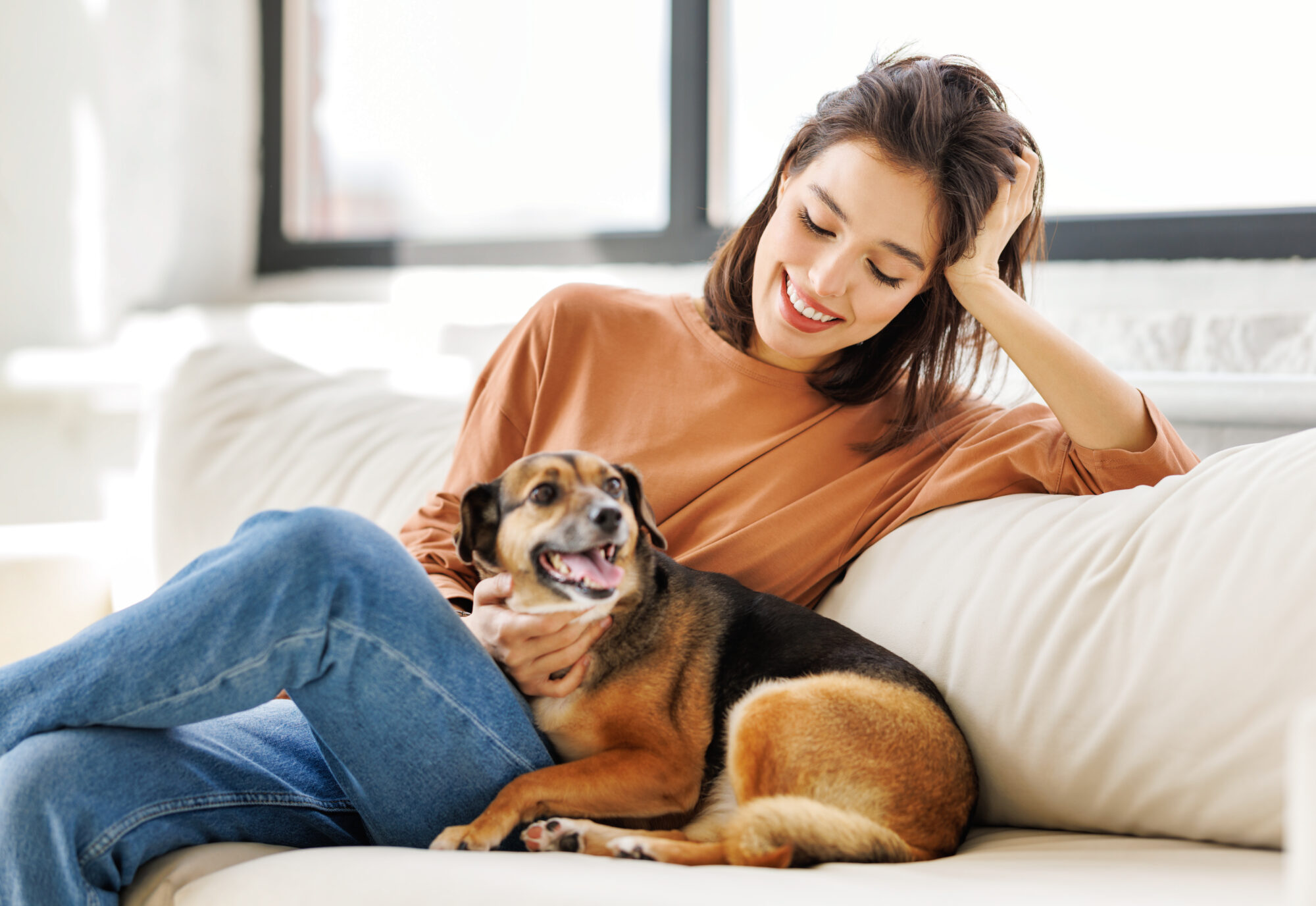 Woman and dog sitting on a couch